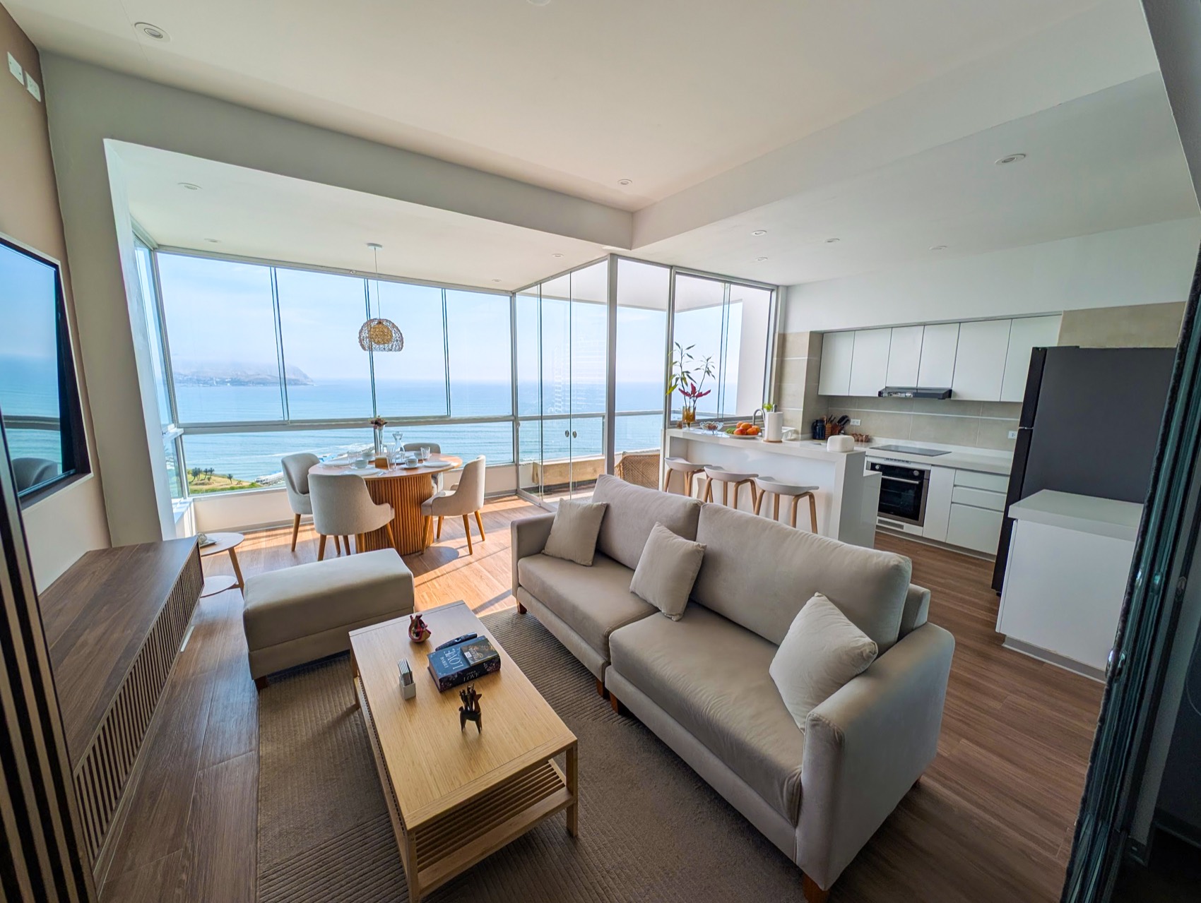 Living and dining area with floor-to-ceiling windows over the Pacific