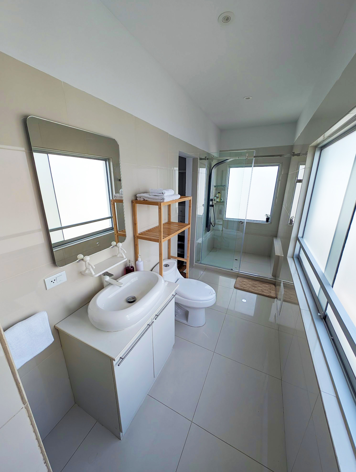 The second full bathroom in the Miraflores apartment, with a glass walk-in shower, vessel sink, and natural light